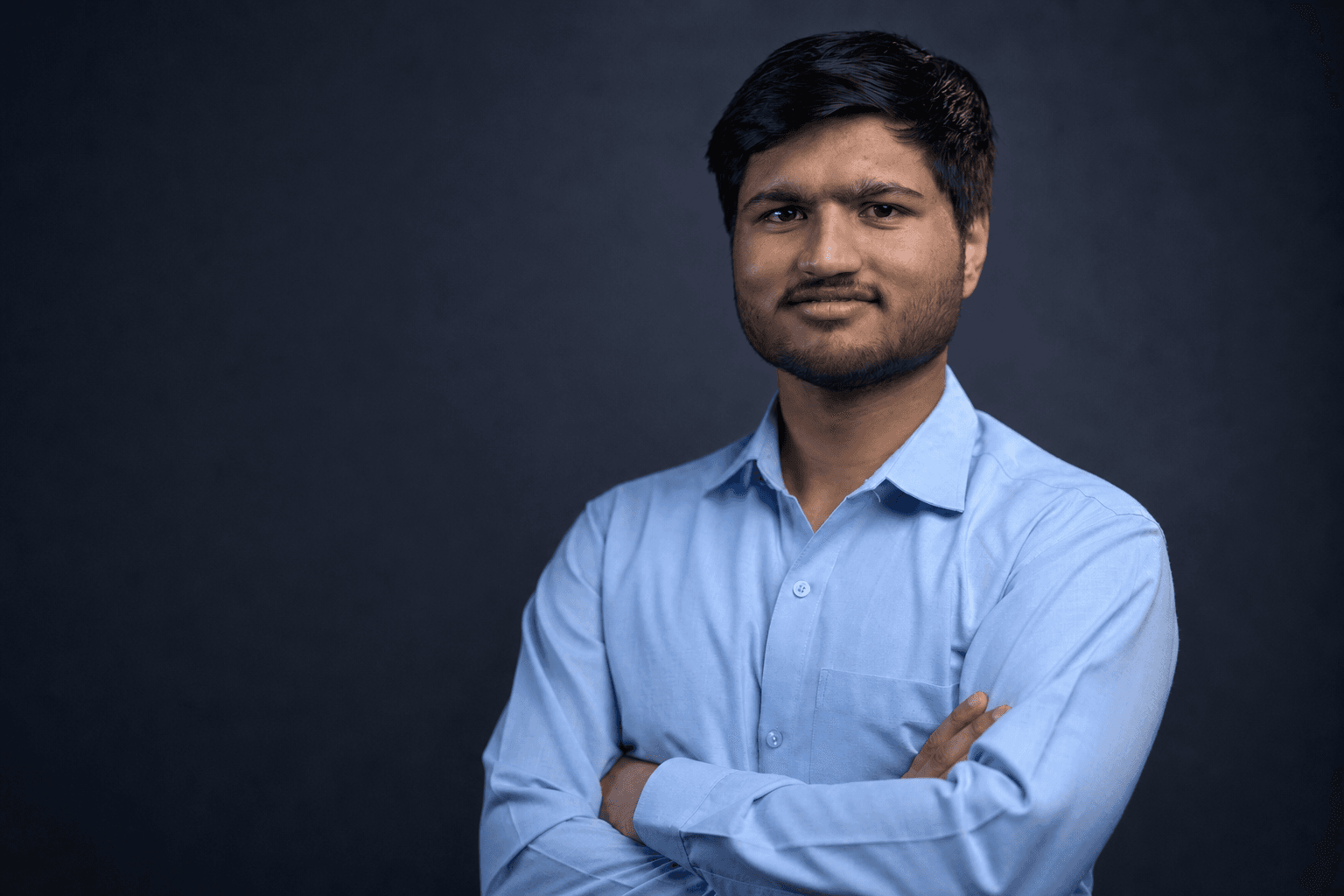 Himanshu Dubey photographed against a dark studio background.